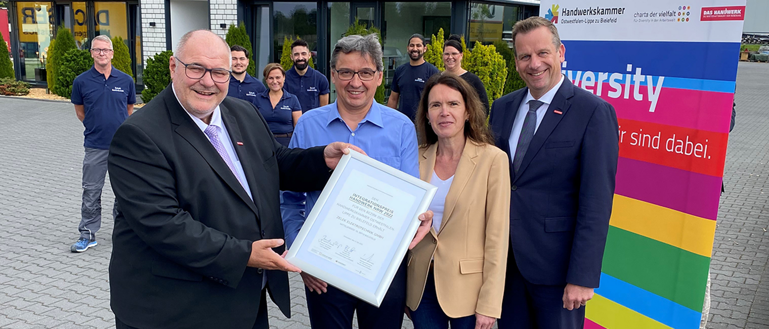 Das Unternehmen Zelek Elektrotechnik GmbH wurde für sein besonderes Engagement mit dem Integrationspreis des Handwerks in NRW ausgezeichnet. Dariusz Zelek (vorne Mitte) erhielt aus den Händen von (v. l.) Peter Eul, Präsident der Handwerkskammer OWL, Kerstin Naumann, Betriebsberaterin der Handwerkskammer OWL, und Dr. Jens Prager, Hauptgeschäftsführer der Handwerkskammer OWL, die Ehrenurkunde, auf der auch NRW-Integrationsminister Dr. Joachim Stamp unterschrieben hat. Das Unternehmen Zelek Elektrotechnik GmbH wurde für sein besonderes Engagement mit dem Integrationspreis des Handwerks in NRW ausgezeichnet. Dariusz Zelek (vorne Mitte) erhielt aus den Händen von (v. l.) Peter Eul, Präsident der Handwerkskammer OWL, Kerstin Naumann, Betriebsberaterin der Handwerkskammer OWL, und Dr. Jens Prager, Hauptgeschäftsführer der Handwerkskammer OWL, die Ehrenurkunde, auf der auch NRW-Integrationsminister Dr. Joachim Stamp unterschrieben hat.