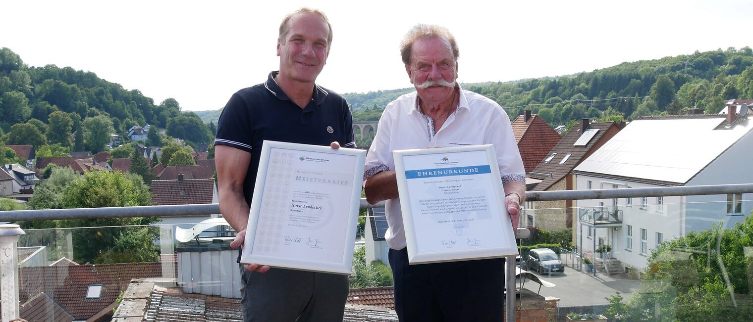 Heiner Dresrüsse (links), Vizepräsident der Handwerkskammer OWL, gratuliert dem Altenbekener Friseurmeister Horst Lendeckel zum Geschäftsjubiläum und Erhalt des Diamantenen Meisterbriefes. 