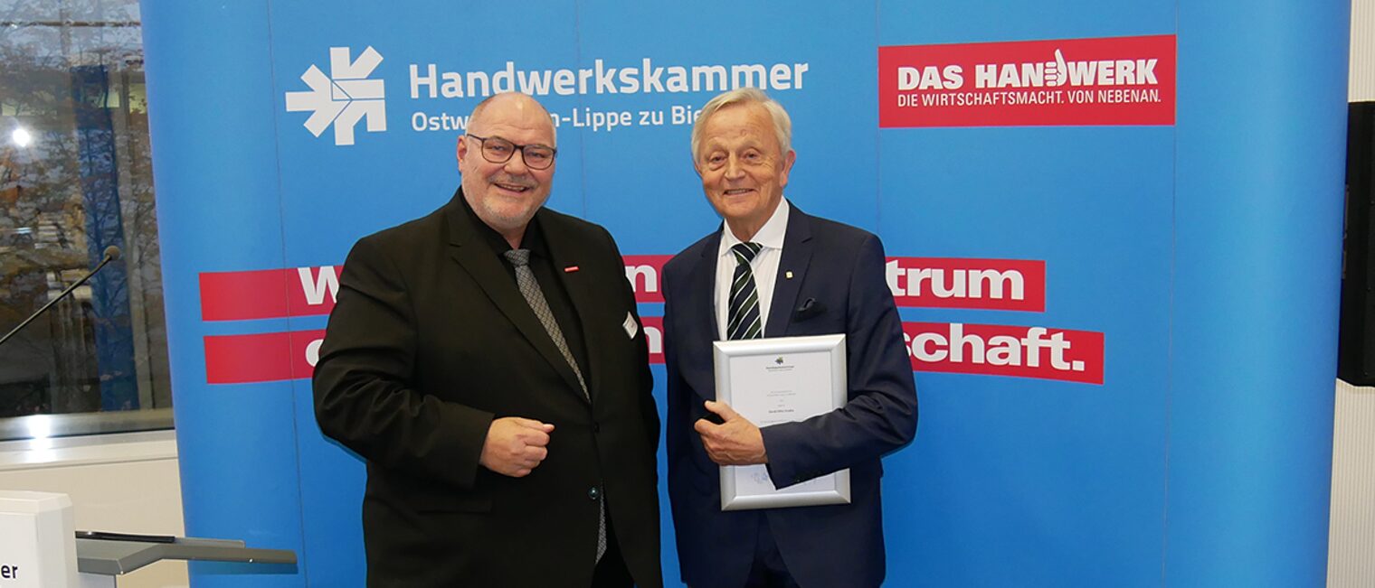 Gerd-Otto Knake (r.) erhält aus den Händen von Kammerpräsident Peter Eul (l.) das Goldene Ehrenzeichen und eine Urkunde der Handwerkskammer OWL. 