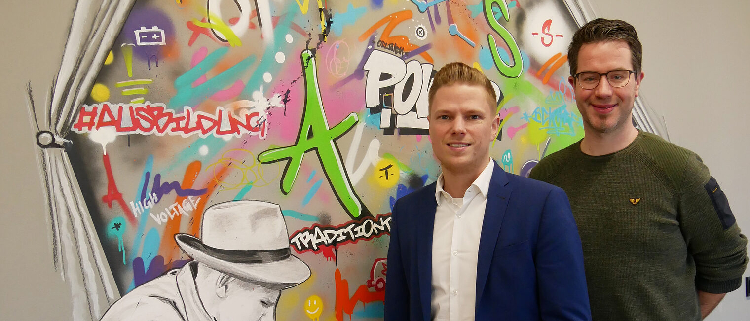 (v.l.) Thomas Beckhoff, Projektleiter Gebäudeautomation, und Ausbildungsmeister Thomas Erdbories vor einem Graffiti im Ausbildungszentrum (v.l.) Thomas Beckhoff, Projektleiter Gebäudeautomation, und Ausbildungsmeister Thomas Erdbories vor einem Graffiti im Ausbildungszentrum