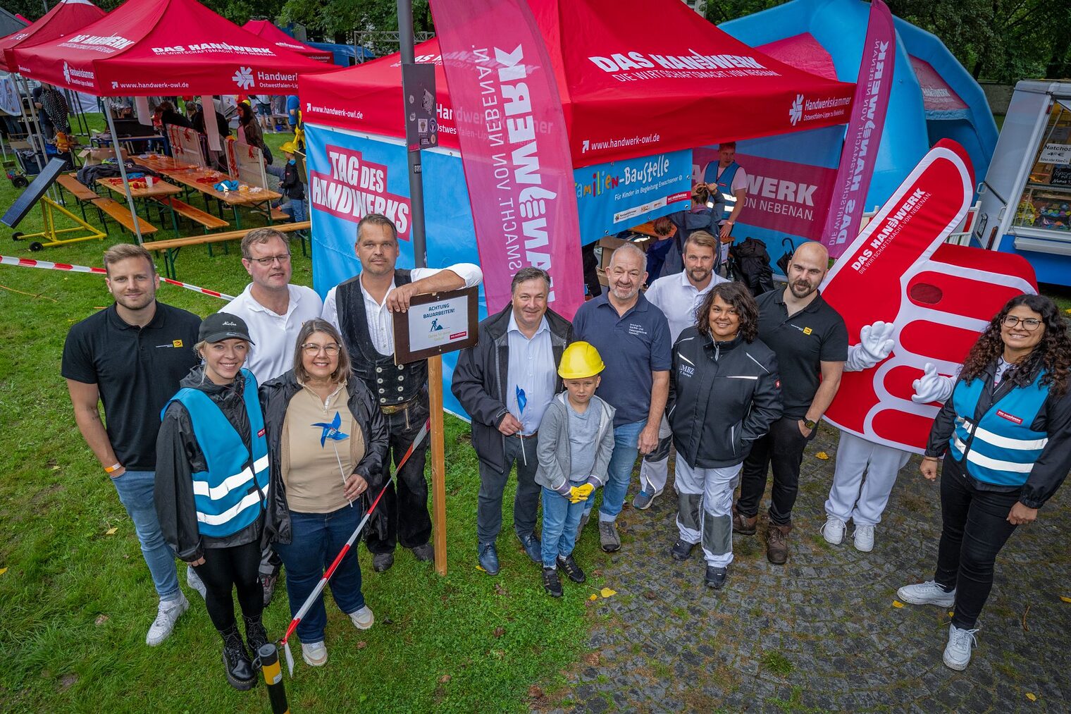 Machten die Familienbaustelle möglich: Julius Stückemann, Fachinnung Elektrotechnik Bielefeld, Emily Giesbrecht, Handwerkskammer, Jörn Schmidt, Handwerksbildungszentrum Brackwede, Dr. Maribel Illig, Handwerkskammer, Jörg Horstmannshoff, Handwerksbildungszentrum Brackwede, Ralf Noltemeyer, Vizepräsident der Handwerkskammer, und Enkel Louis, Thomas Wehmeyer, Innung für Sanitär- und Heizungstechnik Bielefeld, Marcel Düsterhoff, Maler- und Lackierer-Innung Bielefeld, Friderike Borchers, Malerbildungszentrum, Max Schröder, Fachinnung Elektrotechnik Bielefeld, Maskottchen und Dilek Güzel, Handwerkskammer (v.l.).