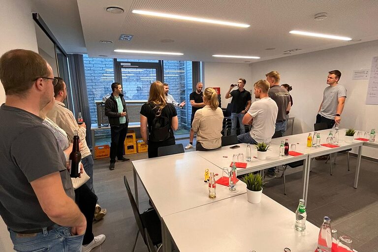 Eine Gruppe junger Menschen unterhalten sich in Seminarraum