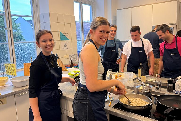 viele junge Leute in der Küche beim Kochen