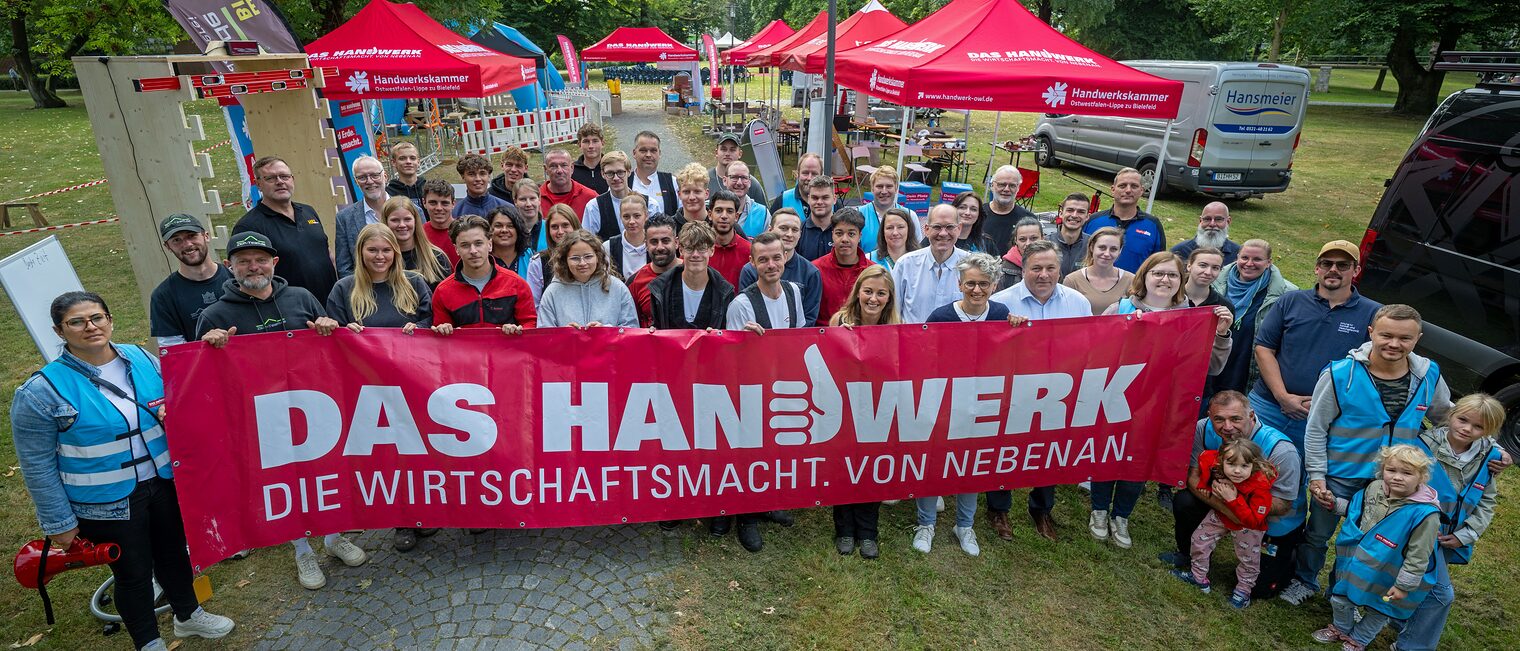 Die Helferinne am Tag des Handwerks stehen hinter dem Banner: Handwerk - die Wirtschaftsmacht von nebenan