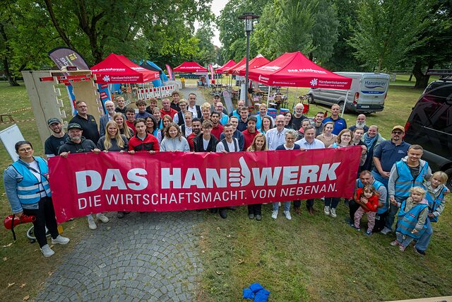 Die Helferinne am Tag des Handwerks stehen hinter dem Banner: Handwerk - die Wirtschaftsmacht von nebenan