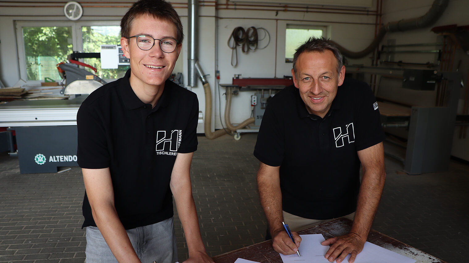 Der Freiwillige Ben Hustert (l.) und Karsten Hoffmann, Inhaber der Tischlerei Hoffmann, bei der Vertragsunterzeichnung
