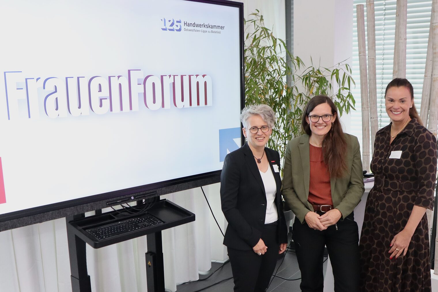 Die drei Vetreterinnen vor dem FrauenForum Logo