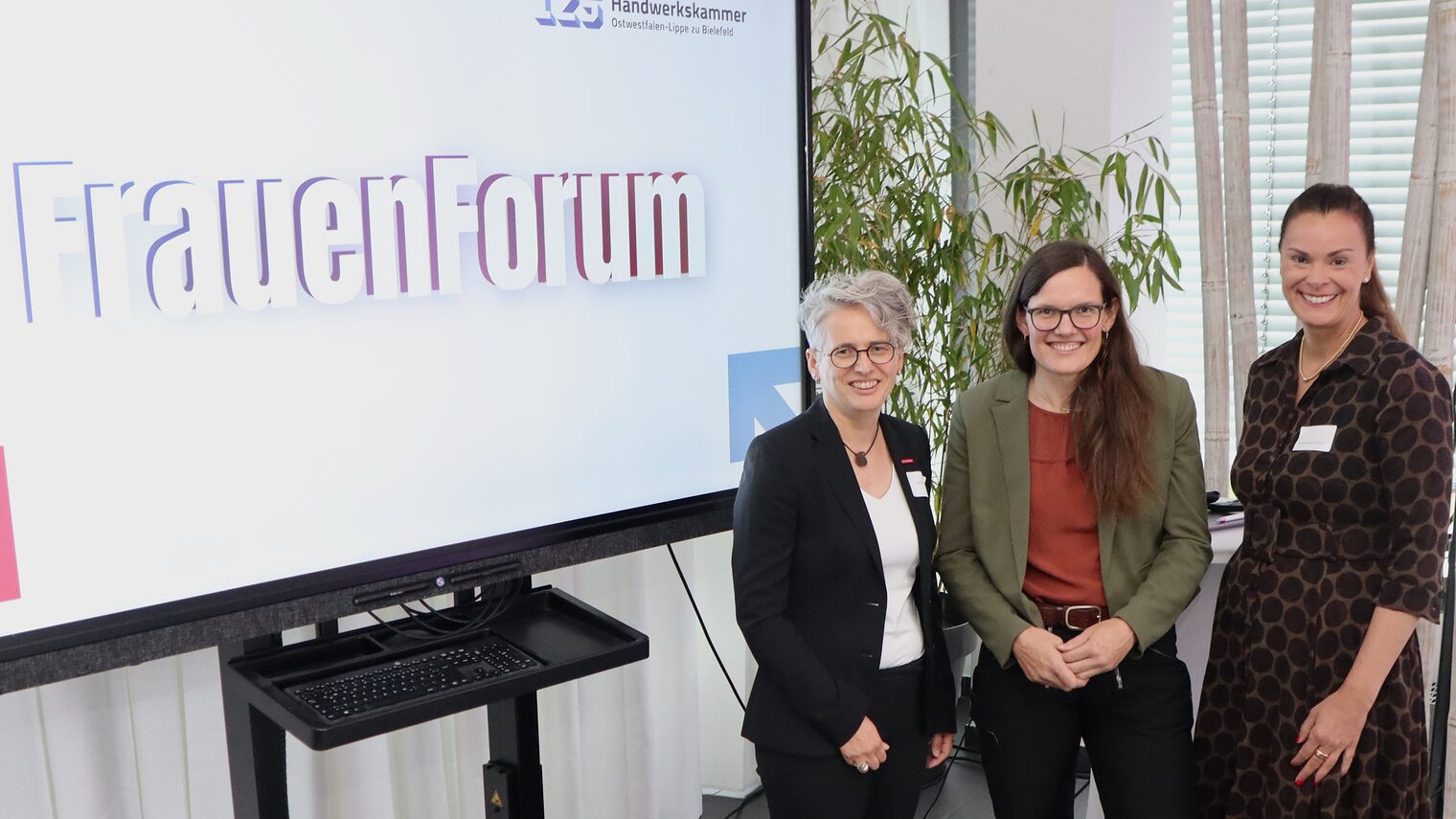 Die drei Vetreterinnen vor dem FrauenForum Logo