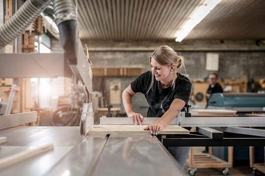Frau arbeitet an der Werkbank.