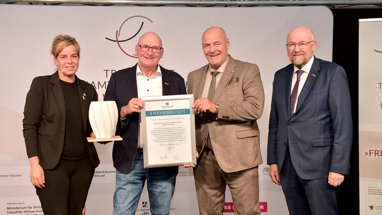 (v. l.) Mona Neubaur, NRW-Ministerin, Preisträger Johannes Grothoff, Peter Eul, Präsident der Handwerkskammer OWL, und Berthold Schröder, WHKT-Präsident