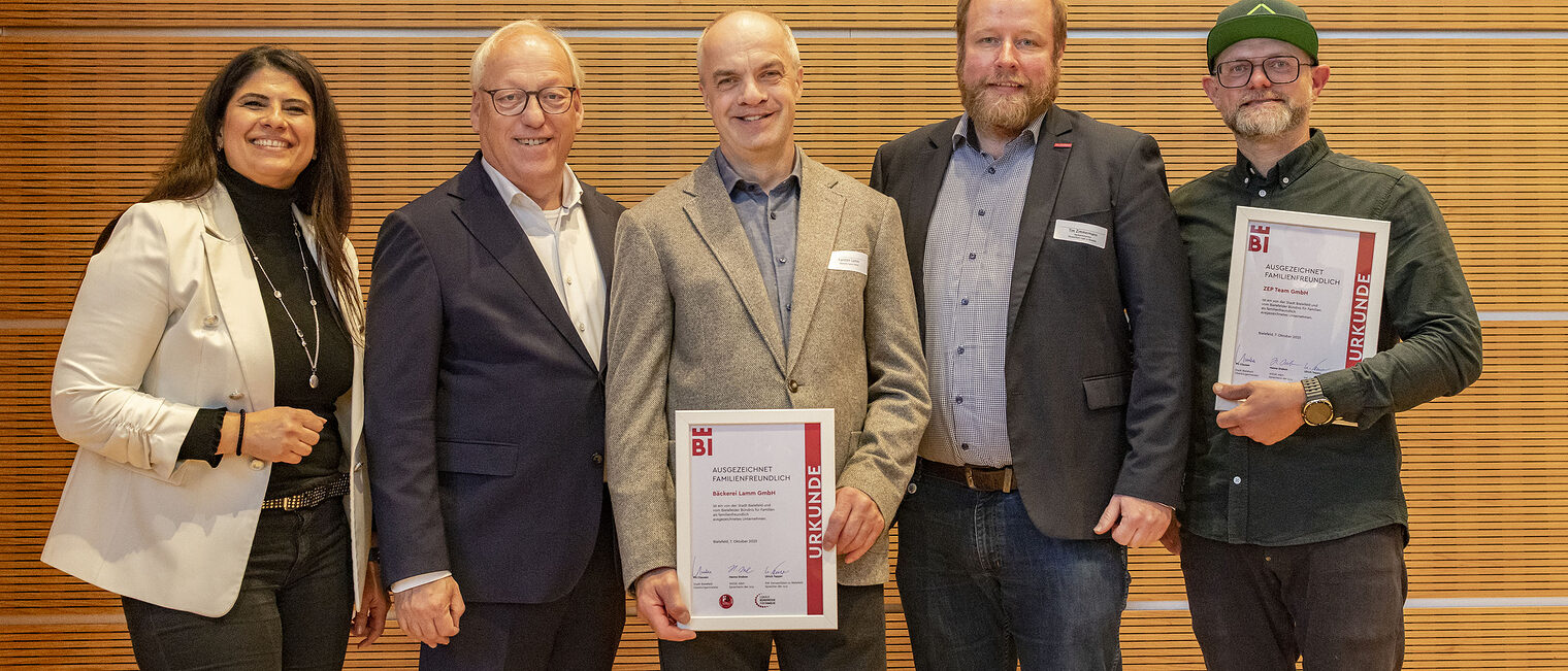 Die Ausgezeichneten mit OB Clausen und Mitarbeiter*innen der Handwerkskammer posieren mit den Urkunden für "Ausgezeichnet Familienfreundlich".