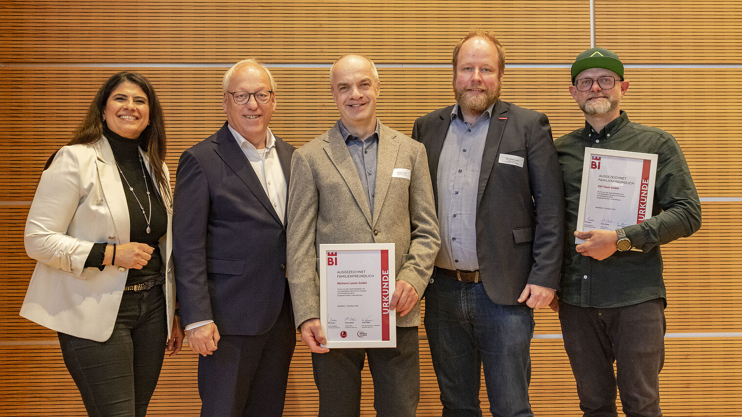 Die Ausgezeichneten mit OB Clausen und Mitarbeiter*innen der Handwerkskammer posieren mit den Urkunden für "Ausgezeichnet Familienfreundlich".