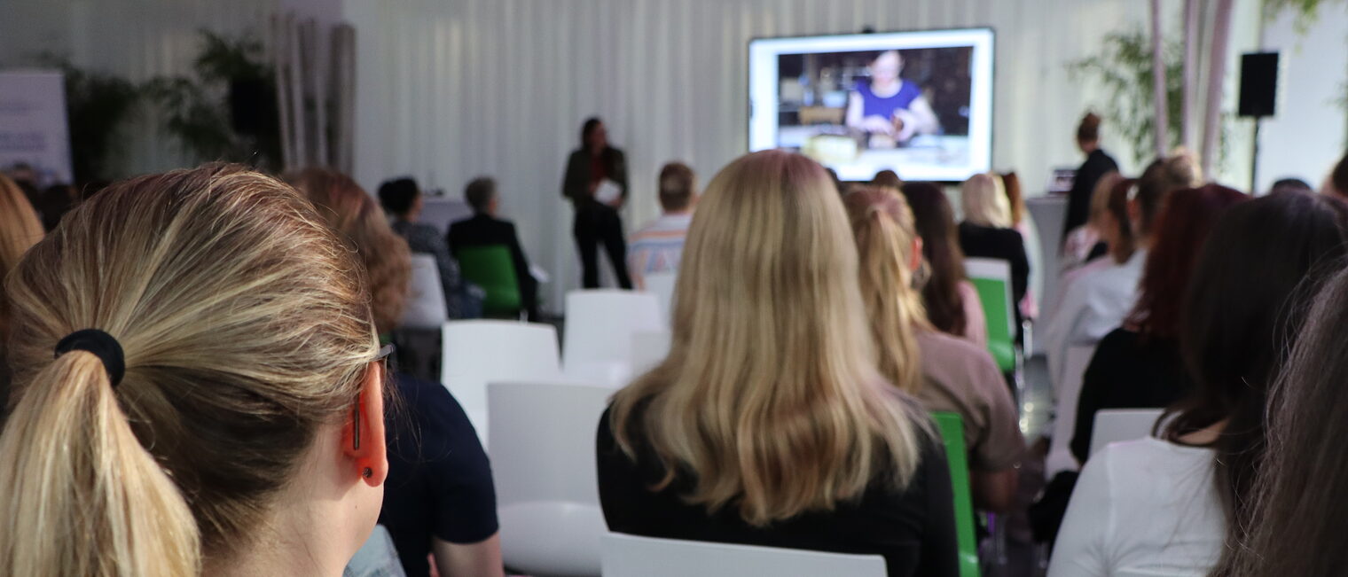 Frauen lauschen einer Rednerin in der Kammer