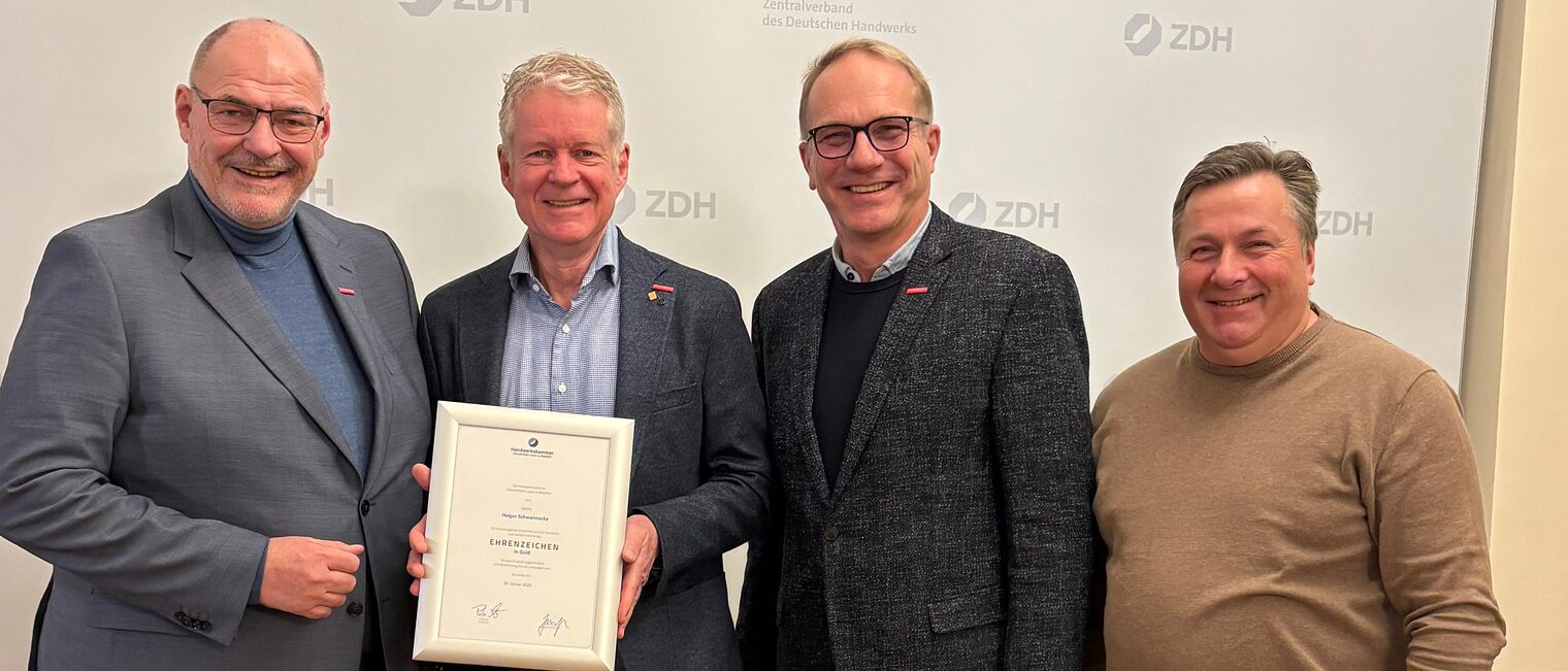 Die Handwerkskammer OWL übergibt Holger Schwannecke die goldene Ehrennadel.