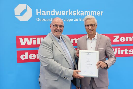 Dietmar Ahle erhält die goldene Ehrennadel von Peter Eul.