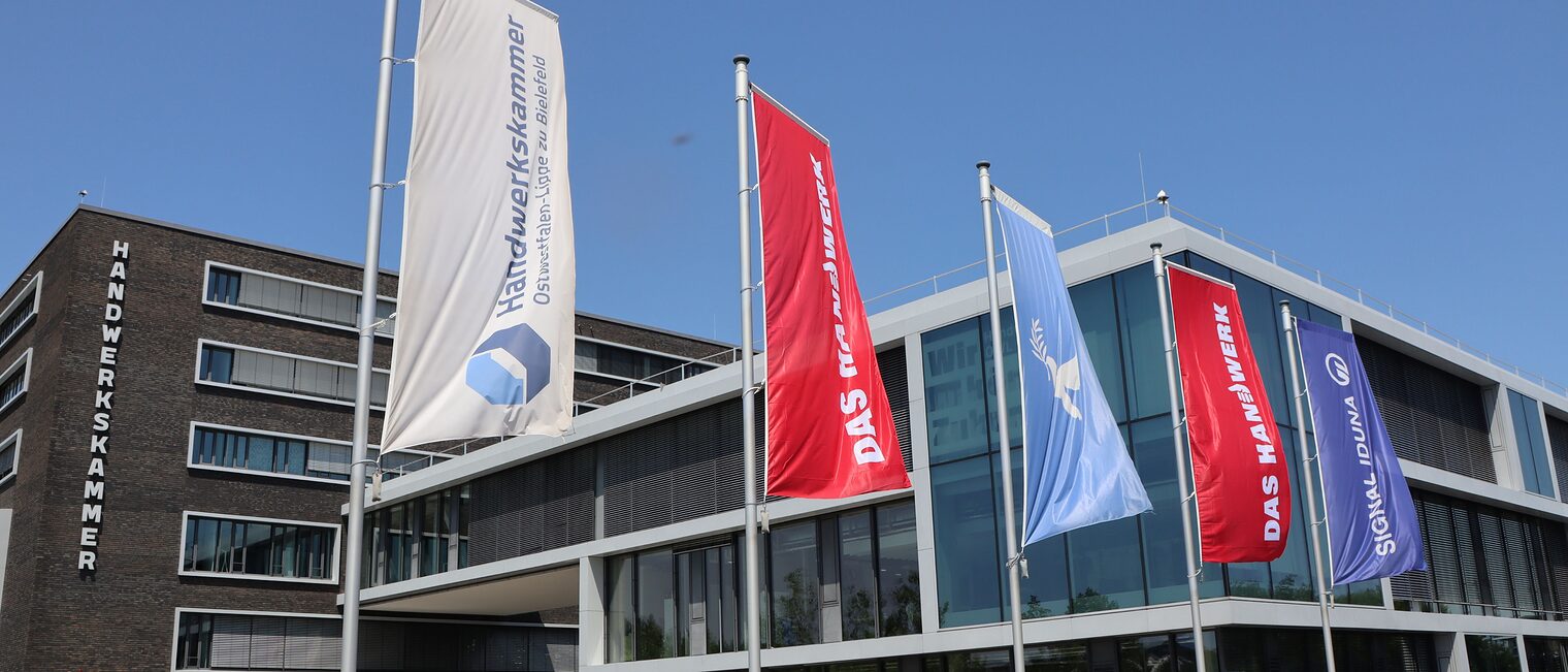 Die Fahnen der Handwerkskammer, von "Das Handwerk", die Friedensfahne und Signal Iduna wehen vor dem HWK-Gebäude.