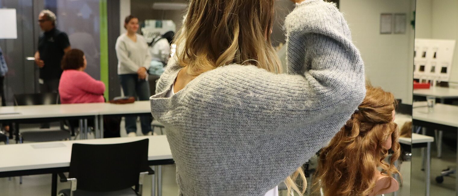 Eine Besucherin macht sich selbst Locken in der Friseur-Werkstatt.
