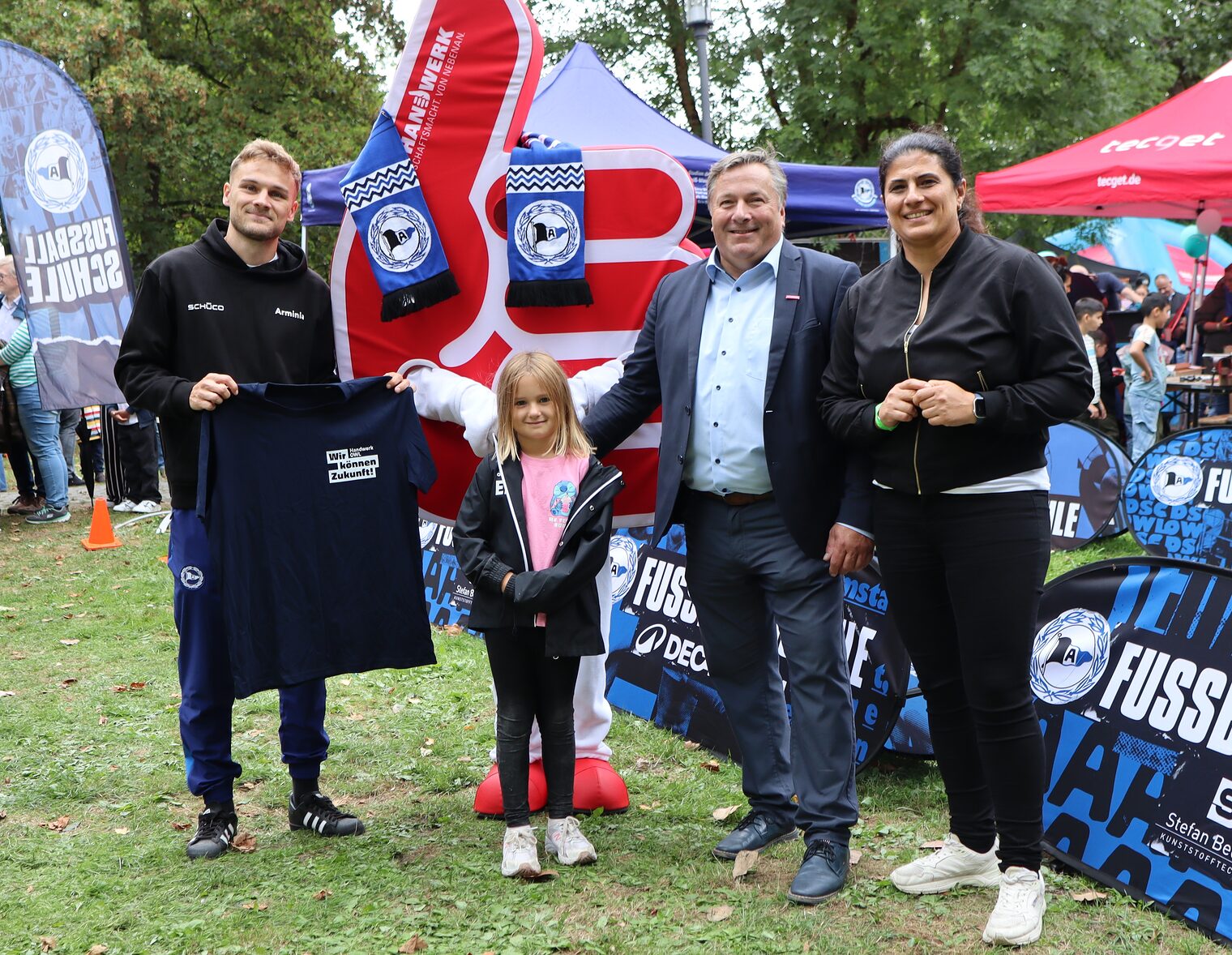 Tim Handwerker mit Maskottchen Daumenik, Emilia, Vizepräsident Ralf Noltemeyer und Dilek Güzel (Leiterin Kommunikation) 