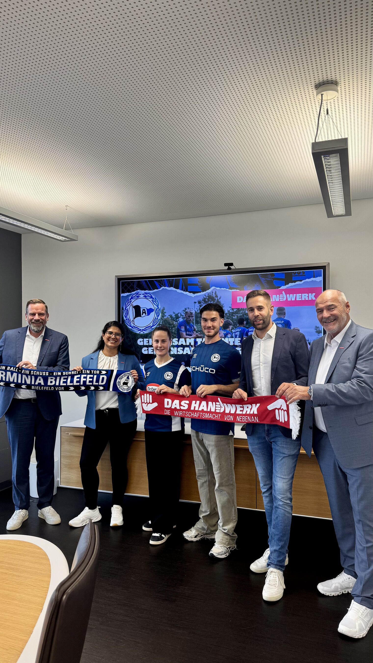 Die Handwerkskammer hält den Arminia-Schal und Arminia hält den Handwerks-Schal.