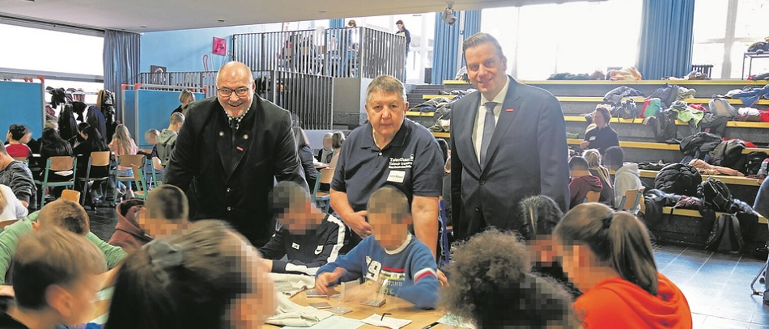 (v.l.) Peter Eul, Präsident der Handwerkskammer, Karin Ressel, Geschäftsführerin vom Technikzentrum Minden-Lübbecke, und Hauptgeschäftsführer Dr. Jens Prager schauen den Siebtklässlern bei ihren handwerklichen Tätigkeiten zu