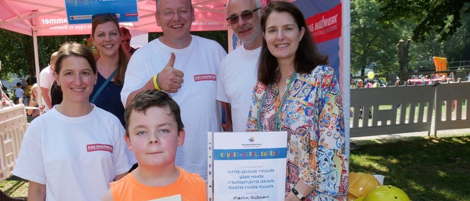 Stolz zeigt Merlin seinen Kindergesellenbrief und das selbstgezimmerte Vogelhäuschen. Das Team Berufsbildung freut sich mit ihm: (v.l.) Tuba Hastaoglu, Stephanie Schadwill, Marwin Schadwill, Siegfried Morawe und Geschäftsführerin Birgit Stehl 
