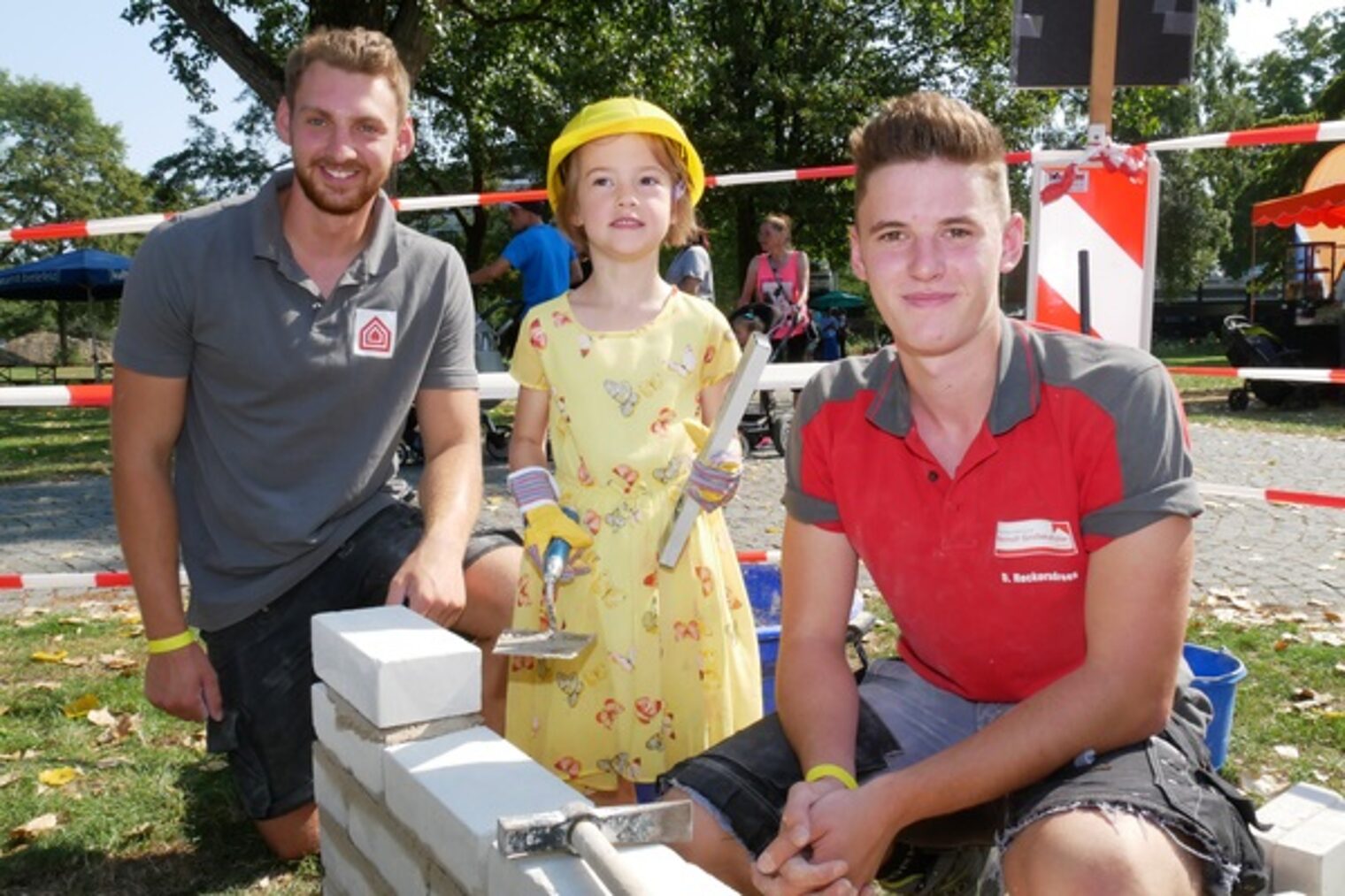 Paul Stork (l.) und Dennis Reckendrees zeigen Zoe, was eine Maurerin können muss